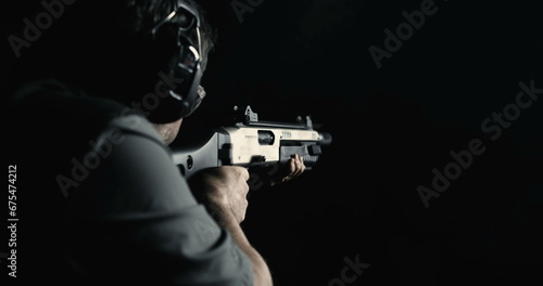 Back of person shooting a shotgun in high-speed captured at 800 fps super slow-motion. Man firing powerful weapon
