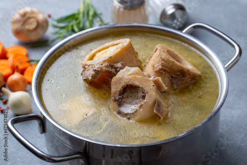Boiled bone and broth. Homemade beef bone broth is cooked in a pot on. Bones contain collagen, which provides the body with amino acids, which are the building blocks of proteins. photo