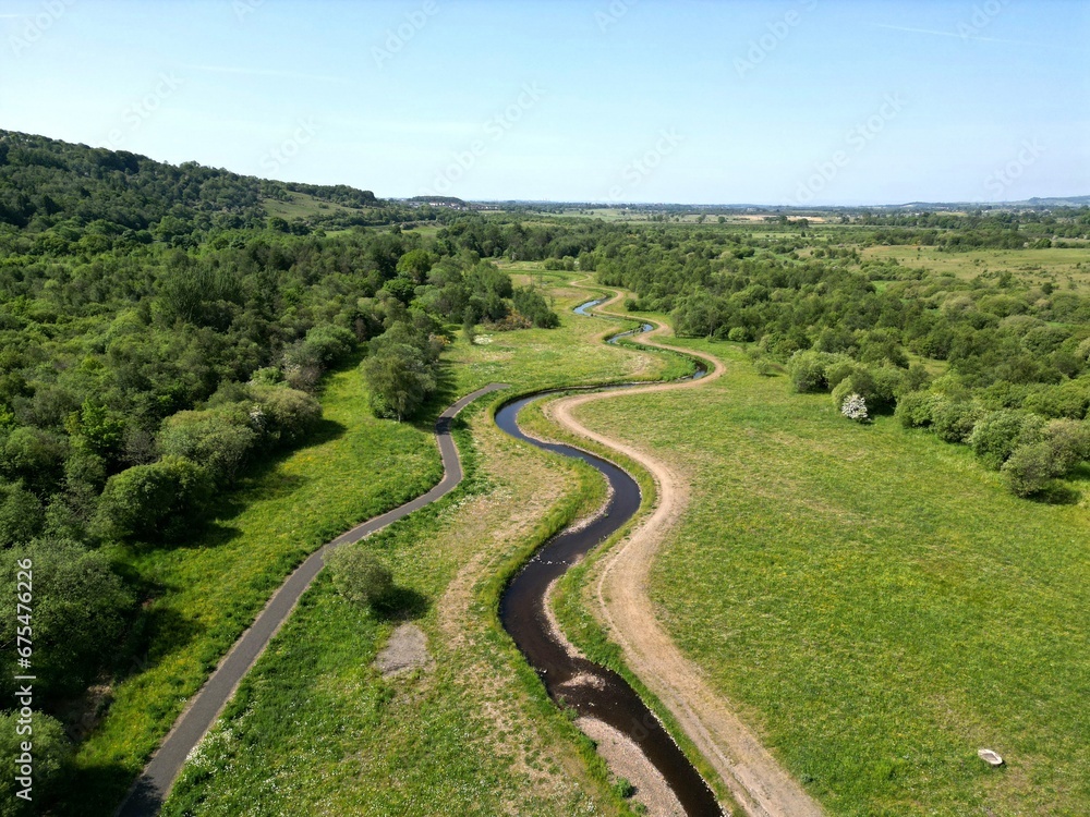Aerial shot of a tranquil river surrounded by lush greenery