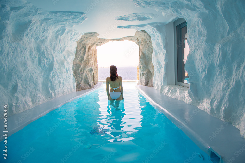 Woman is at Cave style pool with sea view - obrazy, fototapety, plakaty 