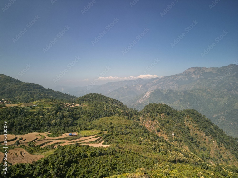 Aerial shot of a scenic valley and mountain range surrounded by lush green vegetation