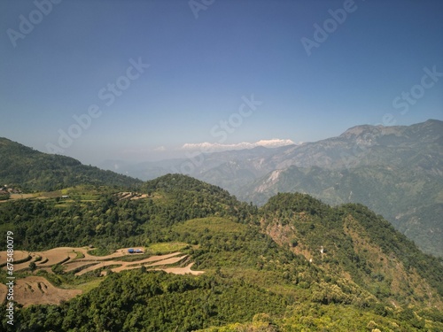 Aerial shot of a scenic valley and mountain range surrounded by lush green vegetation