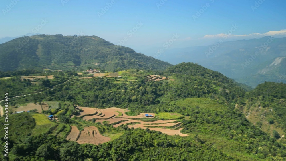 Aerial view of a mountainous landscape featuring lush greenery of grass and trees