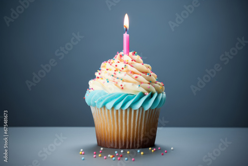 Birthday cupcake with white cream and candle, blue background