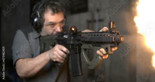 Man aiming and firing an assault rifle in high-speed 800 fps. Shooting with CQR Gun in super slow-motion with bullets flying in the air