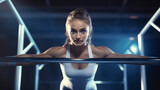 female gymnast is holding on the unparalleled bar and looking straight to the camera
