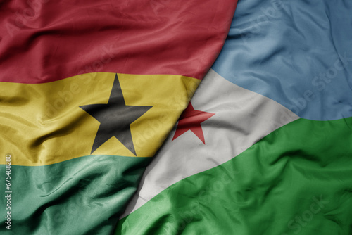 big waving national colorful flag of ghana and national flag of djibouti .