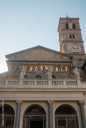 Exterior of the Basilica of Santa Maria in Trastevere with romanesque campanile, ancient mosaics and statues, Rome, Italy