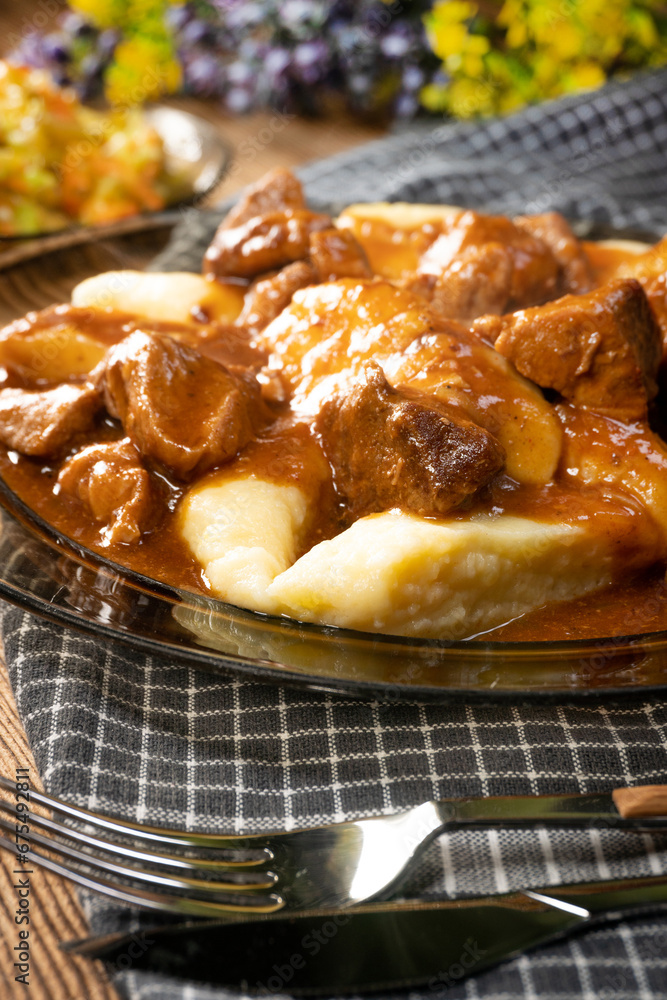 Beef stew in gravy, served with potato dumplings. Beef stew in gravy, served with potato dumplings.
