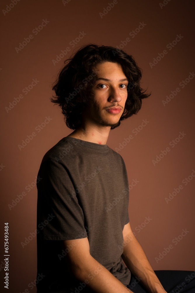 Side profile of a confident Caucasian adult male seated in a comfortable pose Side profile of a confident Caucasian adult male seated in a comfortable pose