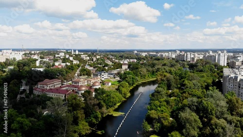 Drone view of people on paddleboards holding a huge Ukrainian flag on the water. The largest flag of Ukraine on the water in Sumy. Many people are sailing on SUP boards and holding the flag of Ukraine