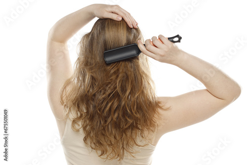 Back,rear view of a young woman brushing healthy hairon a white background