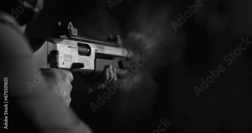 Monochrome shot of person firing a powerful shotgun and reloading shell bullet in black and white photo