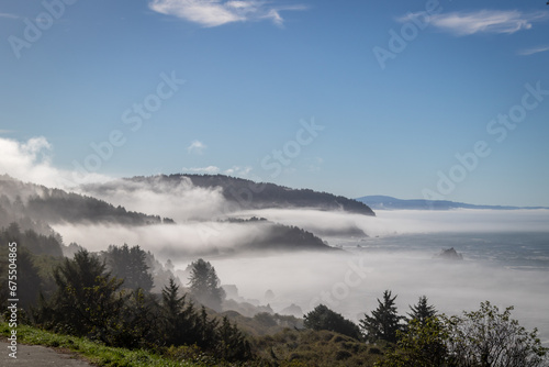 Highway 101 overlook looking down at Wilson creek beach, Image shows a view on top of a hill with low level clouds passing through the hills on a autumn's morning 