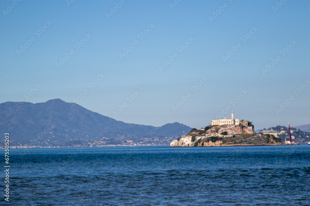 Alcatraz island from the San Francisco bay, Image shows the famous island with a beautiful blue calm sea and the mountain view in the background with clear skies, October 2023