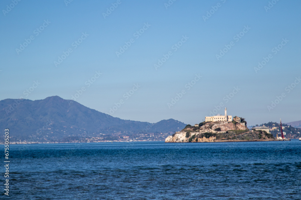 Alcatraz island from the San Francisco bay, Image shows the famous island with a beautiful blue calm sea and the mountain view in the background with clear skies, October 2023 Alcatraz island from the San Francisco bay, Image shows the famous island with a beautiful blue calm sea and the mountain view in the background with clear skies, October 2023