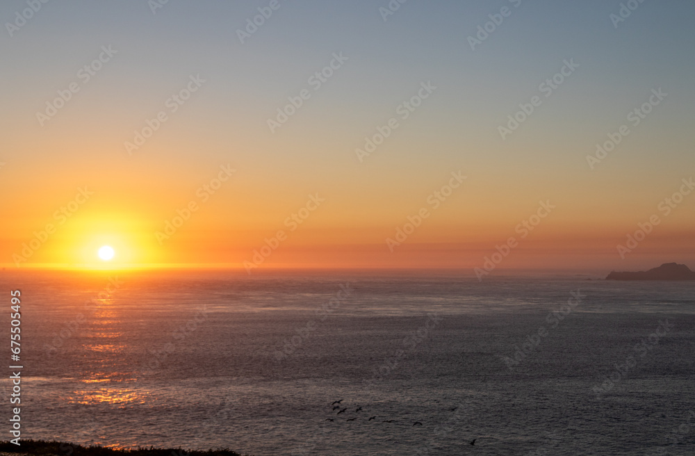 sunset over the pacific ocean, image shows the final moments of the sun setting over the san fancisco bay, california lighting up the sea and sky with various colours, taken october 2023