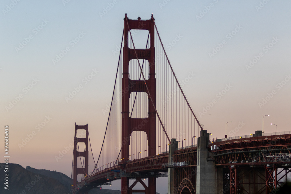 Obraz premium golden gate bridge at sunset, image shows the 2737 meter long bridge built in 1937 on a warm evening with clear skies showing a array of sunset colours, taken october 2023