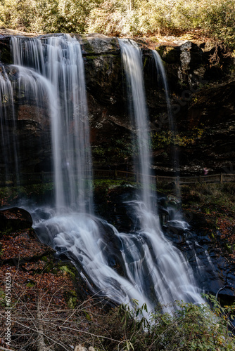 Beautiful high waterfall in fall. Landscape with a mountain river and a waterfall on a sunny autumn day. Dry Falls in Nantahala National Forest  Highlands  North Carolina  USA