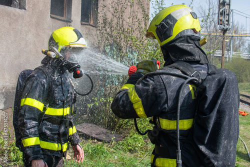 Funny moment where one firefighter washes another with a stream of water from a hose