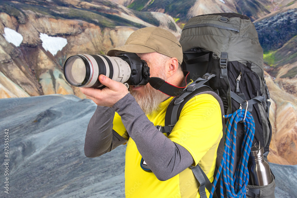tourist photographer with a backpack photographs the beauty of nature in the mountains tourist photographer with a backpack photographs the beauty of nature in the mountains