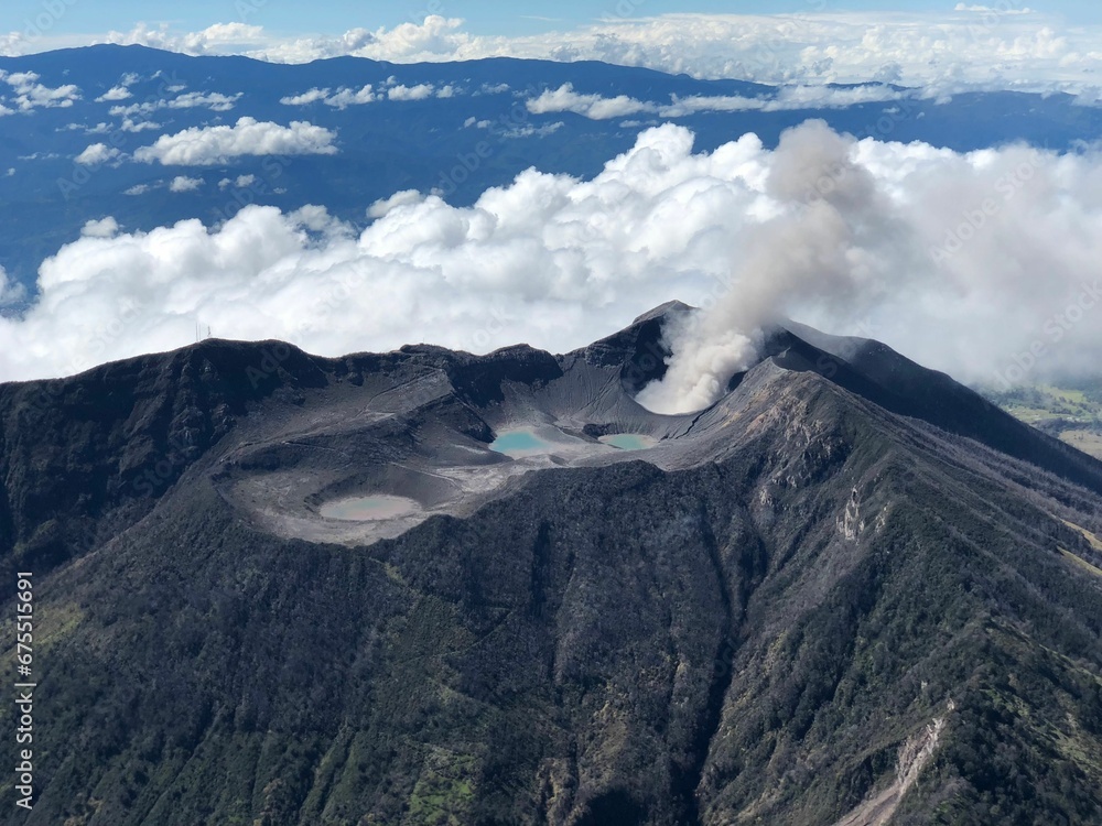 View of an active volcano with billowing clouds in the background