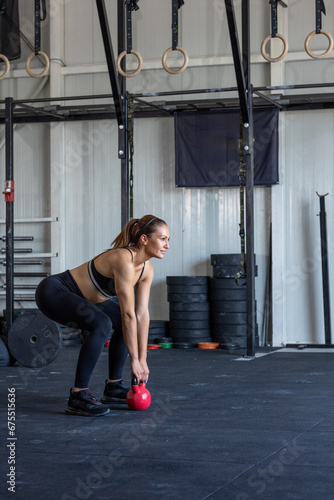 Woman doing kettlebell exercises in the gym