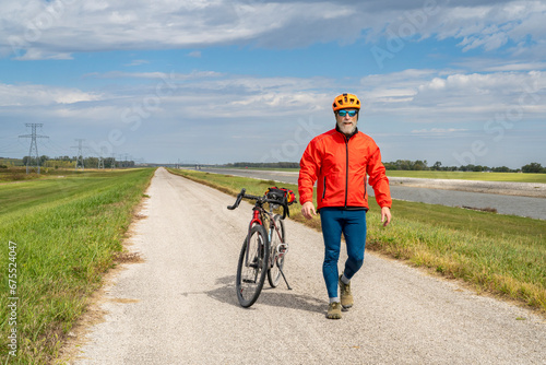 Fototapeta Naklejka Na Ścianę i Meble -  athletic senior cyclist with a gravel touring bike on a levee trail along Chain of Rocks Canal near Granite City in Illinois