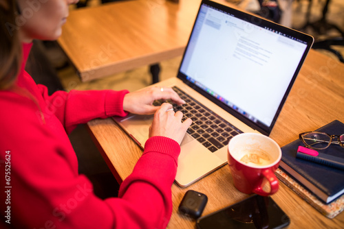 Woman skilled copywriting of homepage working on laptop computer while sitting in coffee shop during recreation time.