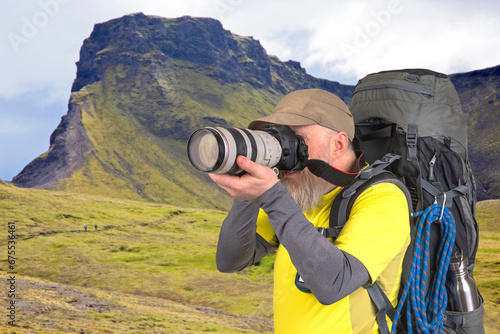 tourist photographer with a backpack photographs the beauty of nature in the mountains