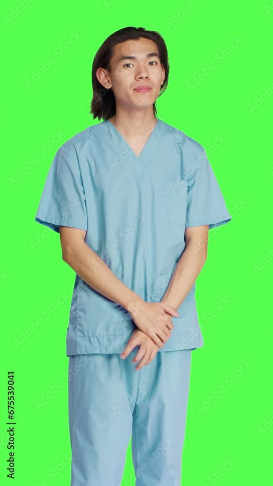 Front view of male nurse nodding on camera and saying yes, showing approval and agreement gesture over greenscreen backdrop. Pleased medical assistant doing good symbol, agreeing with something. Front view of male nurse nodding on camera and saying yes, showing approval and agreement gesture over greenscreen backdrop. Pleased medical assistant doing good symbol, agreeing with something.