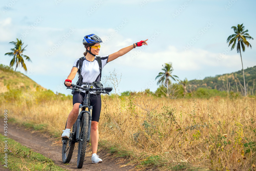 Naklejka premium Beautiful woman cyclist on a bicycle in nature. Healthy lifestyle and sports. Leisure and hobbies