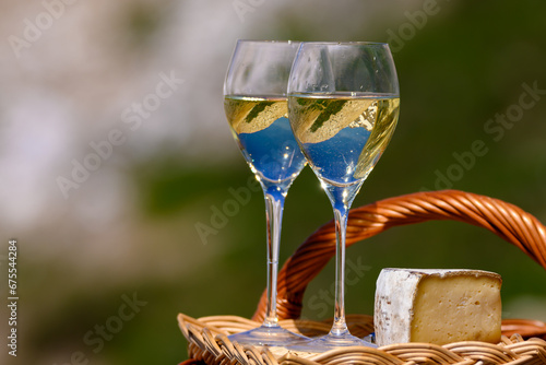 Cheese and wine, dry white Roussette de Savoie or Vin de Savoie wine from Savoy region with tomme cheese served on Col du Galibier border Savoy region, France, view on Alpes mountains