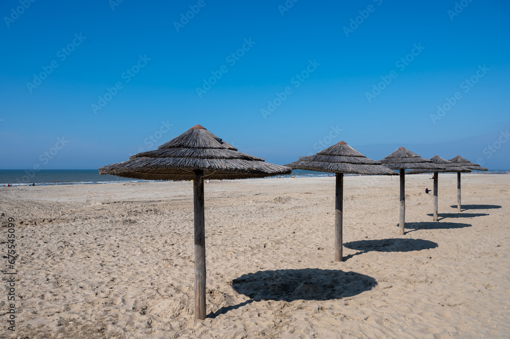 Beach holidays on sandy beach, waterfront relaxation with sun umbrella in Katwijk-on-zee, North sea, Netherlands