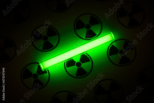 Tritium. Radioactive glow. Gaseous tritium light source in a glass vial. Radiation sign. Green glow hazards to employees, visitors, inspectors. Irradiated zone. Luminous fluorescence, phosphorescence  photo