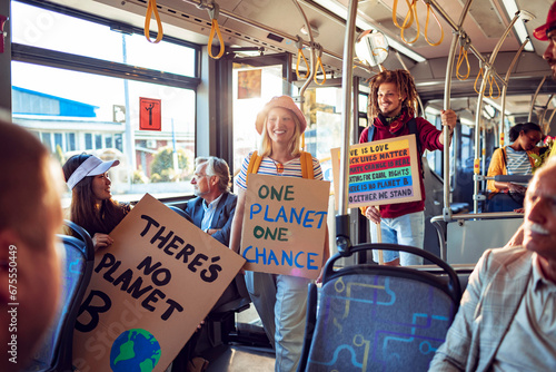 Young people with signs against climate change on the bus