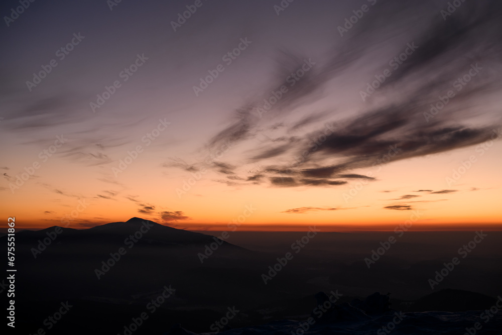 Incredible colors of a sunset sky over distant silhouetted mountains