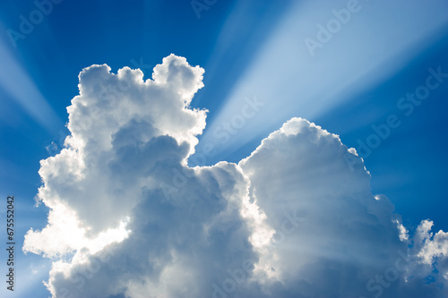 Cloud formations against a blue sky with sun rays  photo