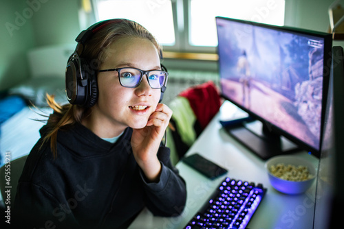 Young gamer girl playing online games on computer