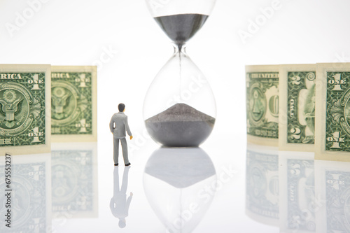 Miniature people. Business people stand near dollar money, hourglass. business concept