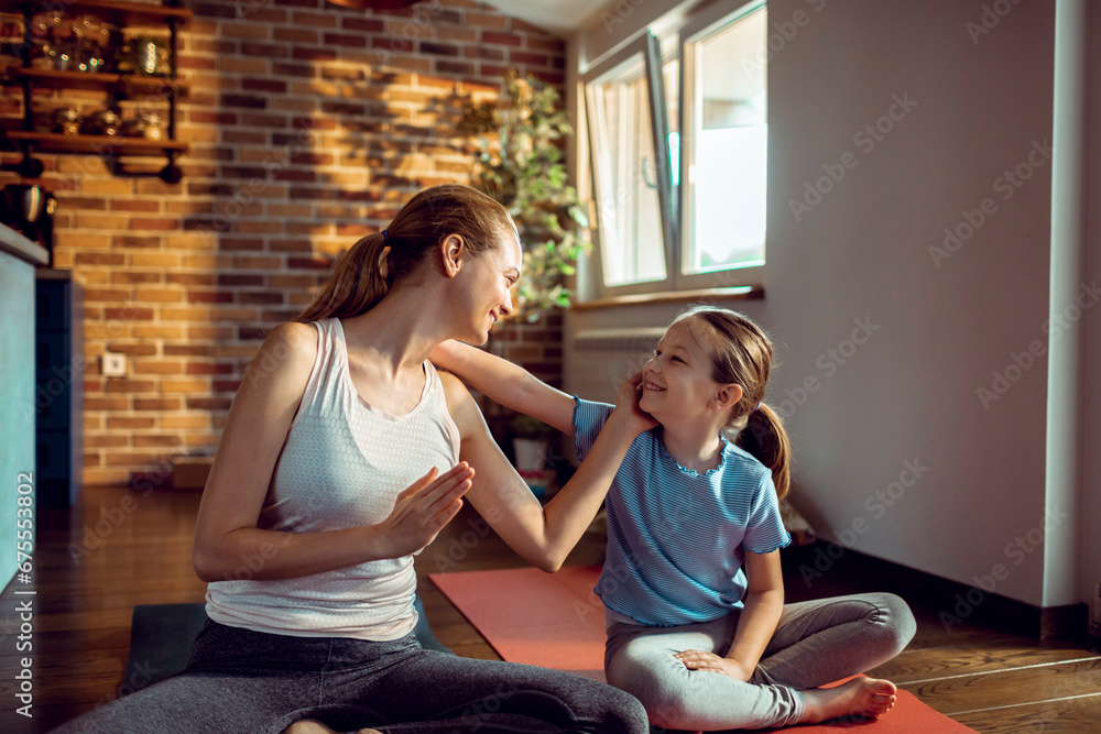 Young mother with little daughter practicing yoga at home Young mother with little daughter practicing yoga at home