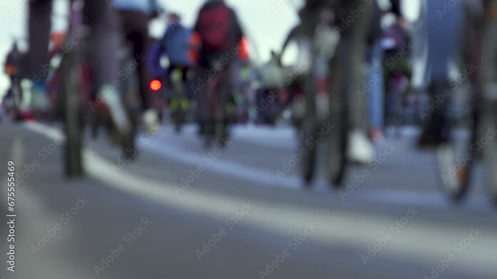A lot of cyclists are riding on road. Unfocused. Close-up of wheels and pedals. Cycling Festival A lot of cyclists are riding on road. Unfocused. Close-up of wheels and pedals. Cycling Festival
