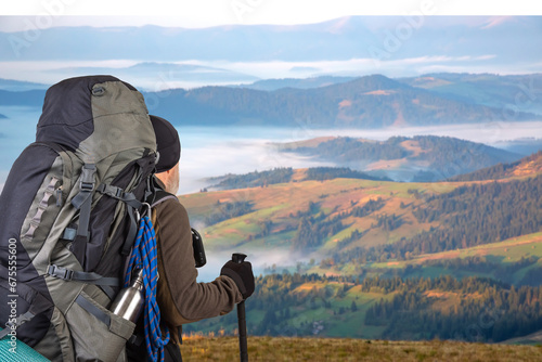 man traveler with hiking equipment on mountain landscape background. nature hikes in the mountains