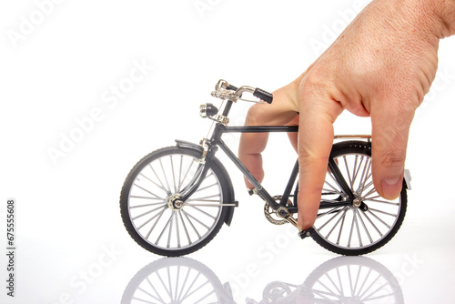 Fototapeta Naklejka Na Ścianę i Meble -  man hand on a bicycle model on a white background. cycling concept