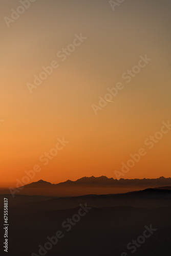 Beautiful view of winter landscape with hills and mountains silhouettes during sunset