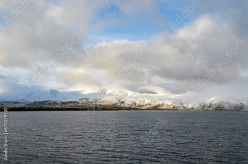 View to calm water surface of lake Sevan and snow capped mountains in distance. Picturesque landmark of Armenia