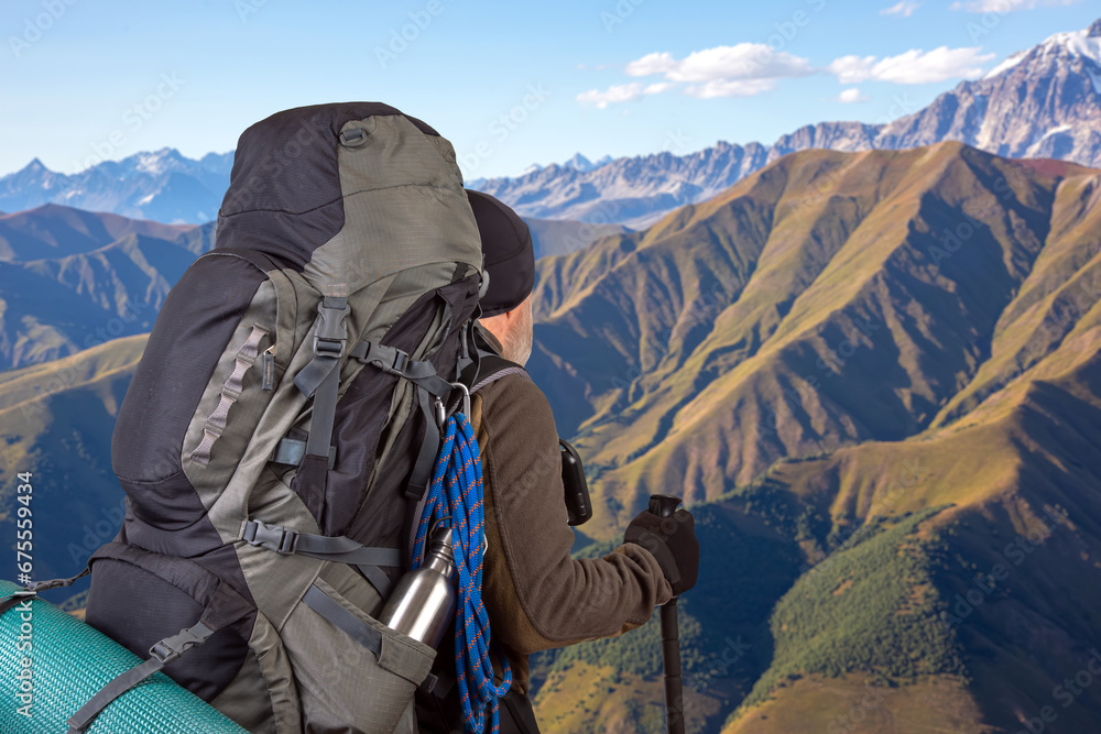 man traveler with hiking equipment on mountain landscape background. nature hikes in the mountains