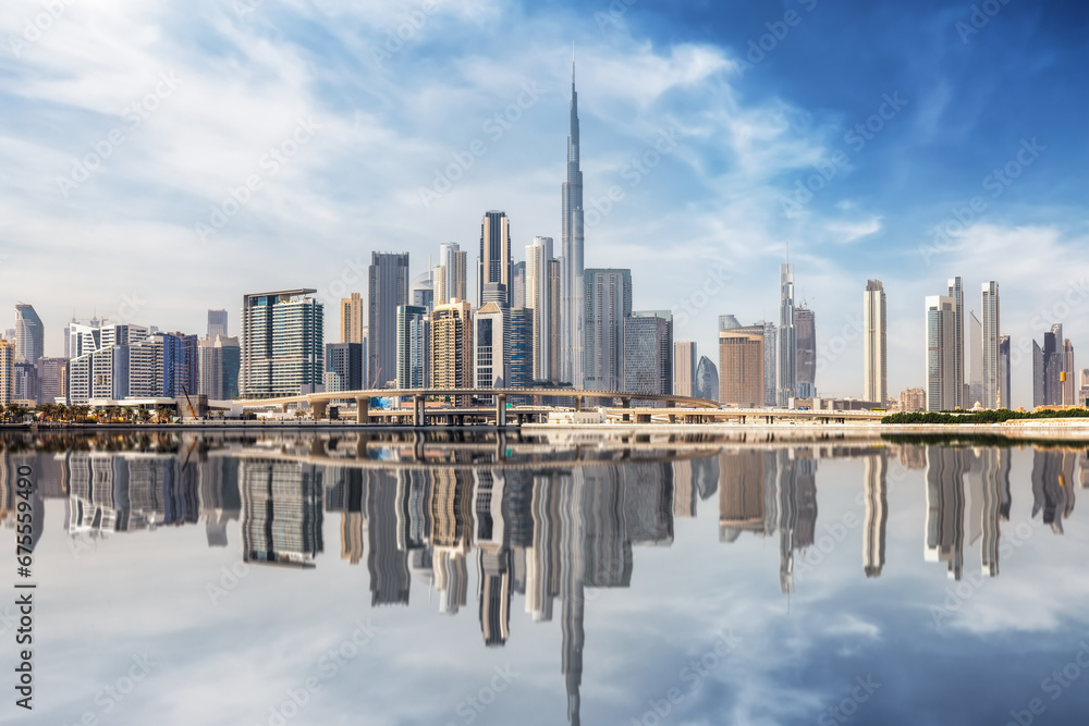The urban skyline of Dubai Business bay with reflections of the modern skyscrapers in the water, UAE
