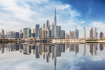 The urban skyline of Dubai Business bay with reflections of the modern skyscrapers in the water, UAE
