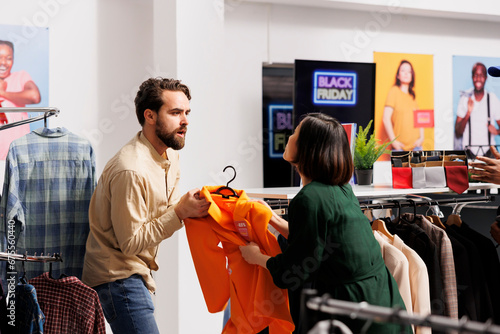 Fotografie Angry mad man and woman shoppers arguing in clothing store